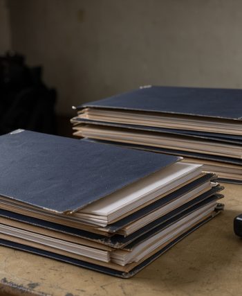Illustration éditoriale sobre montrant des dossiers d’archives judiciaires, un magnétophone de journaliste et la silhouette d’un gendarme dans une ambiance documentaire.
